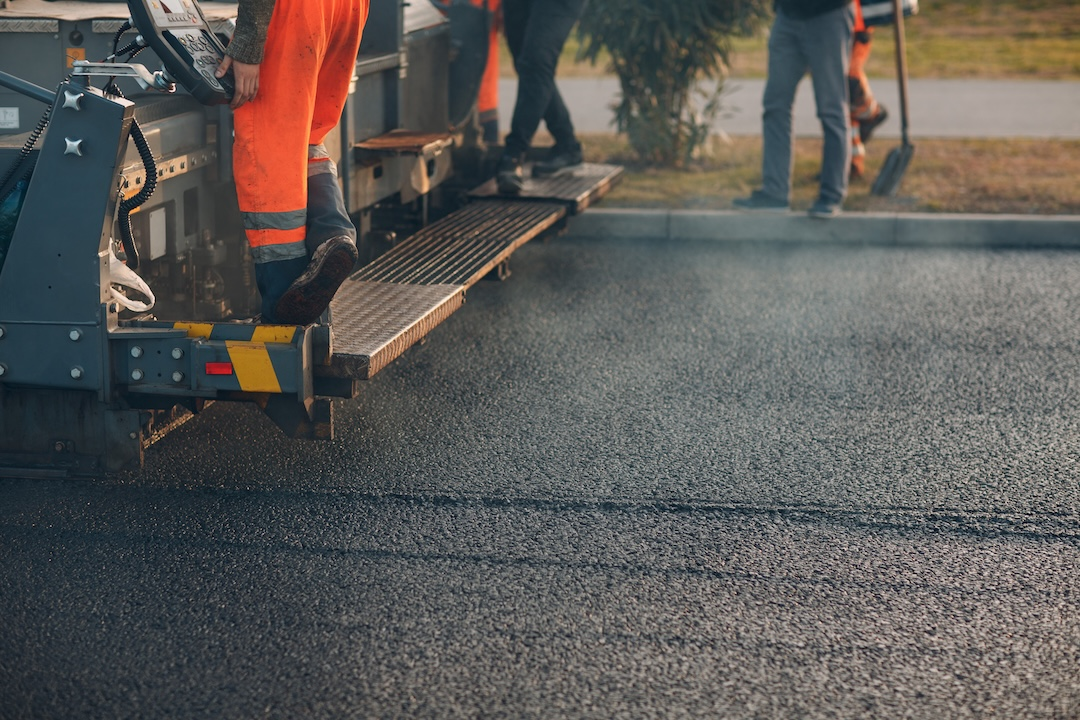 Asphalt paving machine laying fresh hot mix on a jobsite