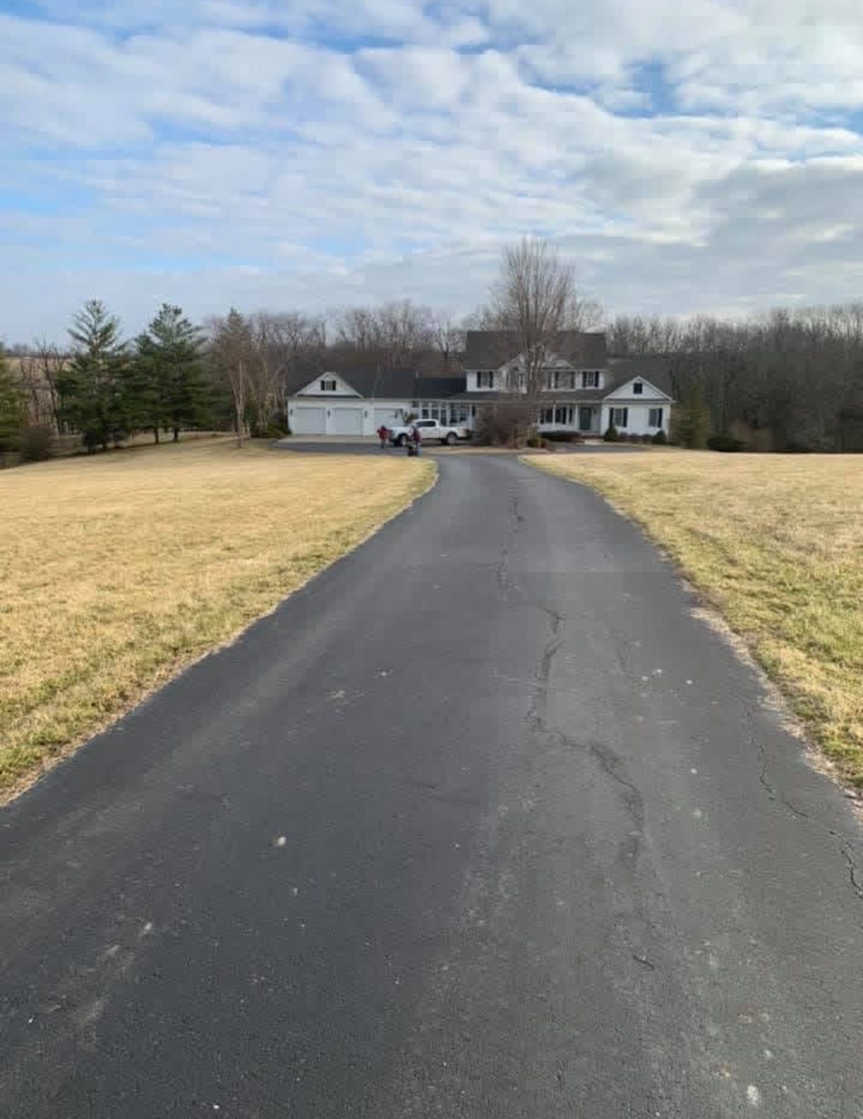 Driveway before work, showing a faded and weathered asphalt surface