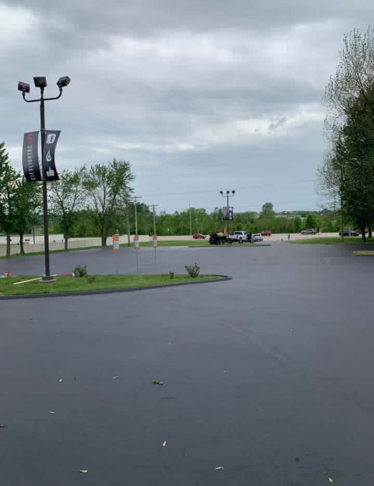 Crew finishing a freshly paved asphalt surface with a rake